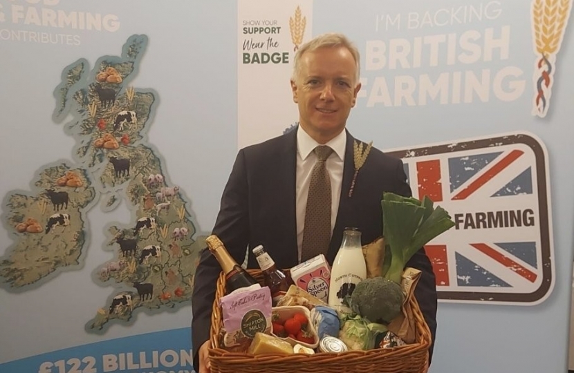 Rob Butler MP holds basket of foods