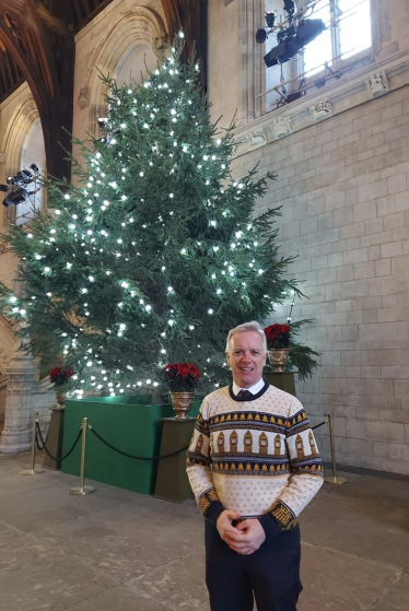 Rob in front of a Christmas Tree in Parliament 